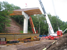 image of a crane by a bridge under construction